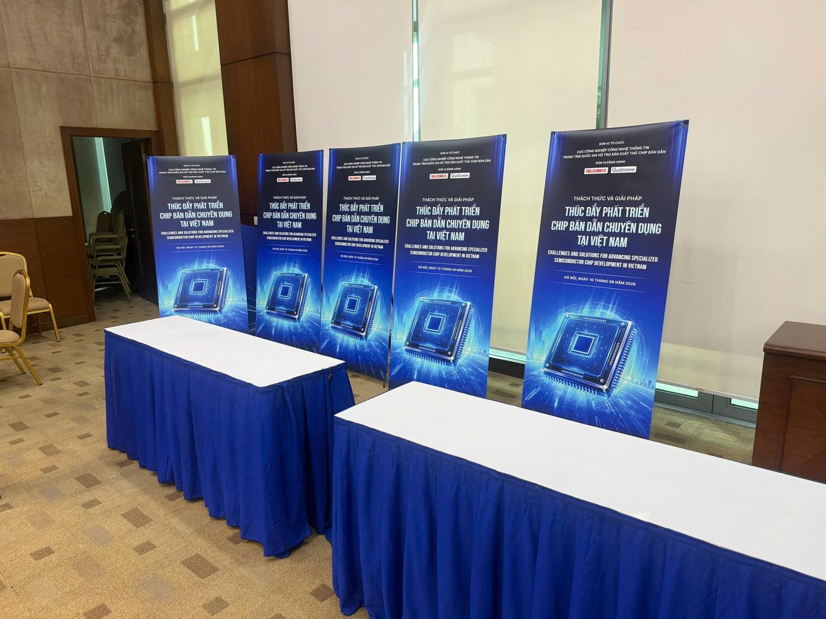 Bàn đón khách check-in phủ khăn và standee tại hội thảo